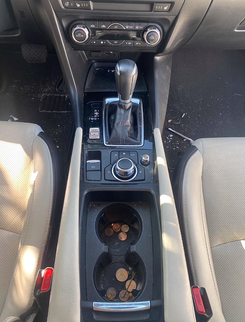 Sticky car console and cup holders with crumbs before console steam cleaning auto interior cleaning in Syracuse UT